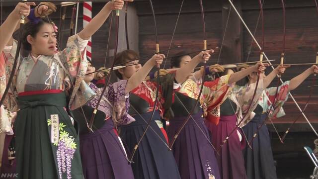 京都市のお寺で新しく成人になった女性たちが弓を引く